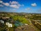 Stunning aerial shot of the cities of Carlsbad and Encinitas with views of buildings, homes, the river, streets with blue sky