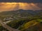 A stunning aerial shot of the majestic mountain ranges with homes along the coastline of California, freeways with cars