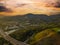 A stunning aerial shot of the majestic mountain ranges with homes along the coastline of California, freeways with cars