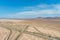 A stunning aerial shot of majestic mountain ranges in a vast desert land with powerful clouds with freeways