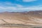 A stunning aerial shot of majestic mountain ranges in a vast desert land with powerful clouds with freeways