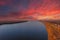A stunning aerial shot of the vast flowing waters of the Mississippi river at sunset with powerful clouds and red sky