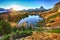 Stunning aerial view of  crystal clear Lake Federa in Dolomites Alps under sunlight in mist and fog