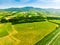 Stunning aerial view of green fields and farmlands. Summer rural landscape of rolling hills, curved roads and cypresses of Tuscany