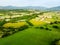 Stunning aerial view of green fields and farmlands. Summer rural landscape of rolling hills, curved roads and cypresses of Tuscany