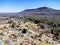 Stunning aerial view of a rural town nestled at the base of a mountain, featuring cluster of houses