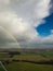 Stunning aerial view of a vivid rainbow arching over a lush green countryside