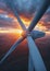 Stunning aerial view of a wind turbine against a fiery sunset sky, symbolizing sustainable energy and power