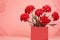 Stunning arrangement of vibrant red carnations in square vase, set against soft pink background. Perfect for adding pop