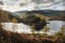 Stunning Autumn Fall landscape of Hawes Water with epic lighting and dramatic sunlight in Lake District