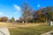 A stunning autumn landscape in the park with gorgeous autumn colored trees, smooth footpaths and tall black light posts