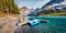 Stunning autumn scene of unique Oeschinensee Lake with small fishing boat.