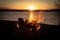 Stunning beachside scene with a bonfire blazing in the foreground at sunset