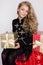 Stunning beautiful little girl with long blond hair holds in her hands gifts,