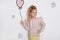 Stunning beautiful little girl with long blond hair standing on a white background and holds a balloon