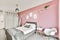 Stunning bedroom with a pink wall and paintings on it