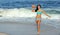 Stunning biracial woman at beach with football