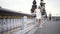 Stunning blonde girl standing on the bridge in white stylish dress on big city background. Action. Sexy plus size model