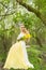 Stunning blonde natural woman swing on a swing on a tree wearing a spring dress