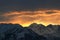 Stunning breathtaking beautiful winter sunrise in the mountains. The sun rays pass through the peaks, illuminating the clouds