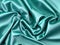 Stunning bright green blue satin silk surface, soft folds on a glossy surface.