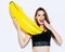 Stunning brunette girl having fun with a huge inflatable banana. On a white background in the studio.