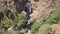 Stunning cinematic 4k aerial of multiple waterfalls among rocks and vegetation