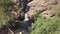 Stunning cinematic 4k aerial of multiple waterfalls among rocks and vegetation