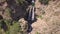 Stunning cinematic 4k aerial of multiple waterfalls among rocks and vegetation