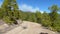 Stunning clouds and mountain forest landscape. Pines along country road with bycicle of photografer. Bright blue sky and beautiful