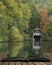 Stunning colorful vibrant Autumn Fall landscape image of boathouse on lake in forest scene coming out of pages in magical story