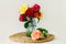 Stunning composition of colorful roses in a glass vase on a wicker napkin