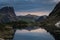 Stunning dawn on the lake. Mountain Spirits Lake in Ergaki on an summer morning among the taiga rocks with dramatic sky and tree