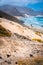 Stunning desolate landscape of sand dunes and desert plants in front of ocean waves on Baia Das Gatas in background