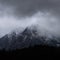 Stunning detail landscape images of snowcapped Pen Yr Ole Wen mountain in Snowdonia during dramatic moody Winter storm