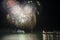 Stunning fireworks display over sea with pier and boats in wate