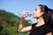 Stunning fitness girl drinking water during running at the park