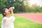 Stunning fitness woman drinking water from bottle during running at the stadium in sunny morning. Empty space