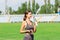 Stunning fitness woman drinking water and listening music after running at the stadium in sunny morning. Sports and healthy