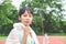 Stunning fitness woman wiping sweat and holding a bottle of water after Jogging outdoors at the stadium in sunny morning