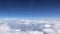 Stunning footage of aerial view above clouds from airplane window with blue sky. view from the airplane window to the