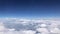 Stunning footage of aerial view above clouds from airplane window with blue sky. view from the airplane window to the