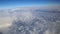 Stunning footage of aerial view above clouds from airplane window with blue sky. view from the airplane window to the