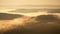 Stunning golden hour light sunrise with flowing clouds among mountains