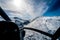 Stunning helicopter cockpit image with snowy Mount Aspiring in the background on a sunny winter day, New Zealand