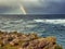 Stunning Irish seascape with rough stone coast line and powerful Atlantic ocean and colorful rainbow. Kilkee area, Ireland.