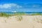 Stunning landscape with marram grass growing in the dunes and a ferry going along the coast in northern France