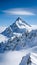 A stunning landscape of a snow-covered mountain peak rising above the clouds, contrasted by a clear blue sky