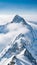 A stunning landscape of a snow-covered mountain peak rising above the clouds, contrasted by a clear blue sky