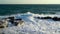 Stunning landscape of stormy sea. The wind drives the waves onto the rocks, the water breaks with white foam